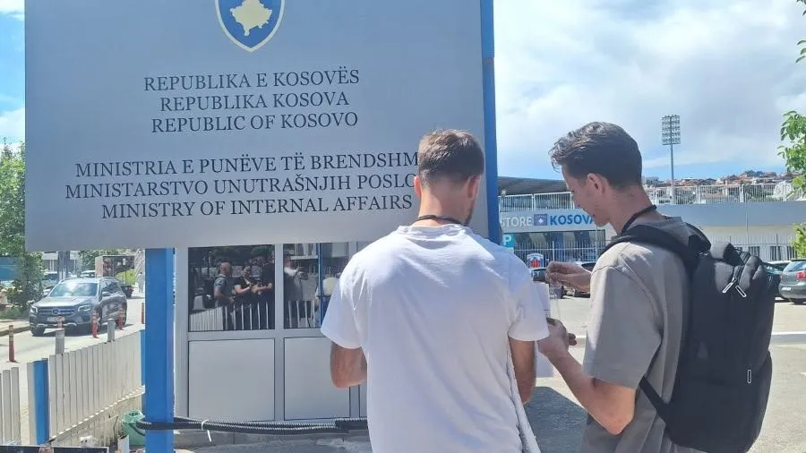 Dy aktivistë para tabelës së Ministrisë së Punëve të Brendshme në Prishtinë