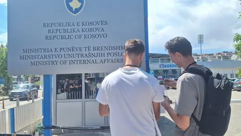 Dy aktivistë para tabelës së Ministrisë së Punëve të Brendshme në Prishtinë