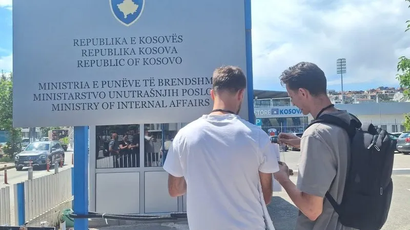 Dy aktivistë para tabelës së Ministrisë së Punëve të Brendshme në Prishtinë